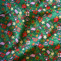 Christmas-themed fabric with various festive elements on a green background