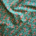 Floral fabric pattern with small flowers on a green background
