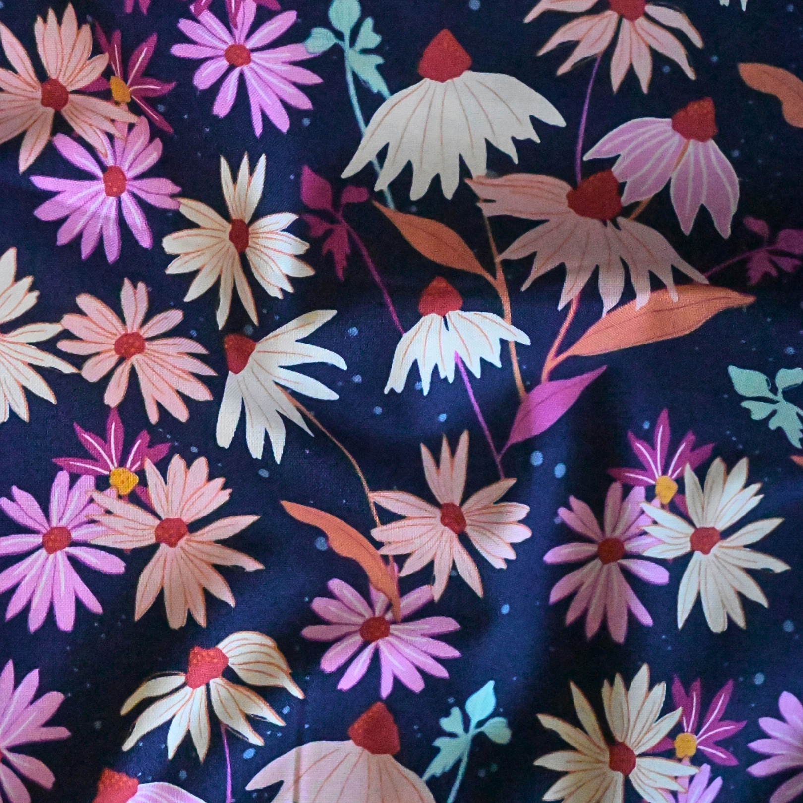 Floral pattern with pink, white, and orange flowers on a dark blue background