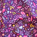 Close-up of floral fabric pattern with pink, purple, and yellow colors on a dark background.