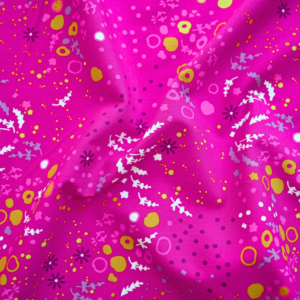 Pink fabric with colourful floral and abstract patterns