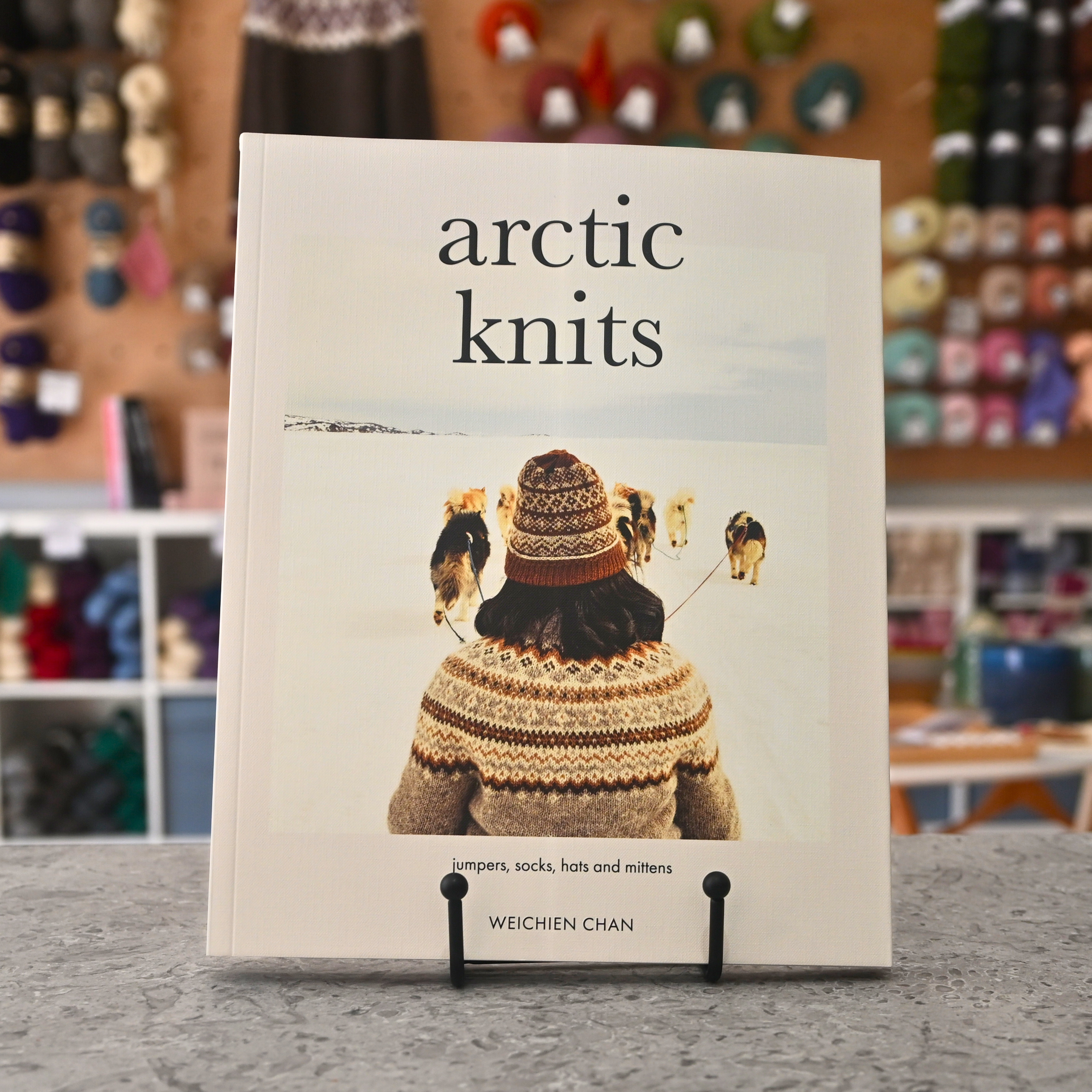 Arctic Knits book by Weichien Chan — jumpers, socks, hats and mittens — cover showing colourwork knitted jumper and Arctic landscape