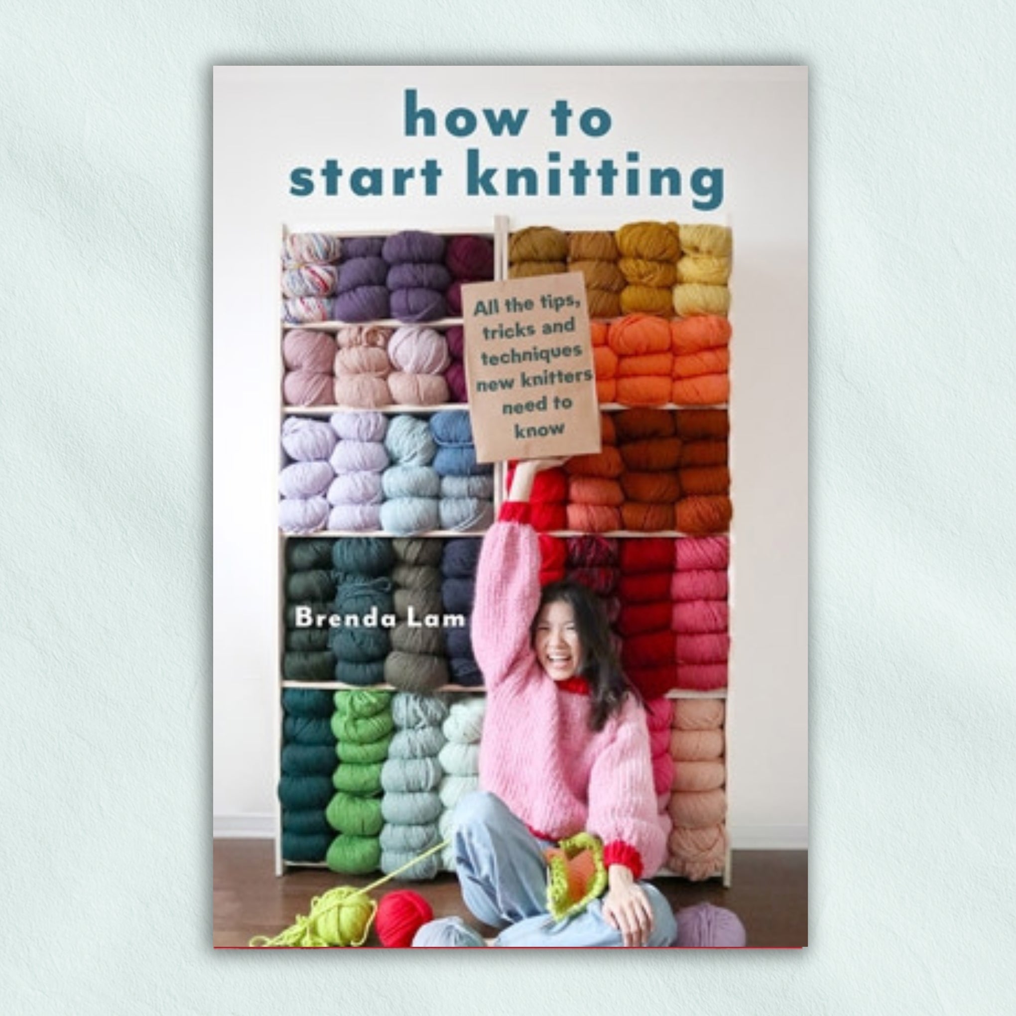 Book cover of 'How to Start Knitting' by Brenda Lam with colourful yarn.