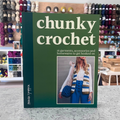 Chunky Crochet book by Amanda Ljunggren — cover showing chunky crocheted garments and homewares. Blurred craft shop background.