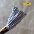 DMC 6-Strand Cotton Embroidery Floss – 03 Medium Grey – 8m skein, 100% Egyptian cotton. Fabric background (blurred).