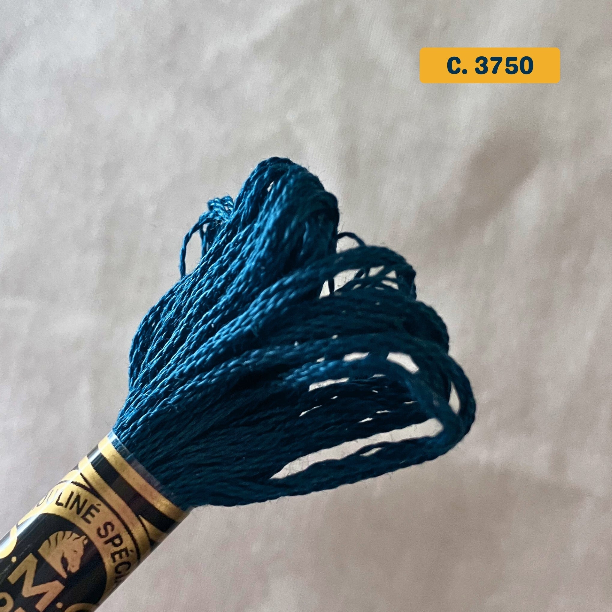 DMC 6-Strand Cotton Embroidery Floss – 3750 Dark Blue – 8m skein, 100% Egyptian cotton. Fabric background (blurred).