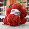 50g red (brickworks) Peruvian highland wool DK yarn, 'Haynes Creek Heathers by Gathering Yarn' label visible, craft shop background (blurred)
