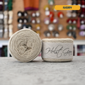 50g ivory lambswool‑merino‑cotton light fingering skein, 'Holst Garn' label visible, craft shop background (blurred)