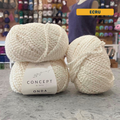 50g natural white (ecru) boucle textured cotton worsted yarn, 'Concept by Katia Odna 100% Plant-based Yarn' label visible, craft shop background (blurred)