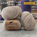 50g grey-beige (oyster white) organic cotton sport yarn, 'Fair Cotton 100% Organic Cotton Katia' label visible, craft shop background (blurred)
