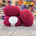 50g red (plum) mohair & silk lace yarn, 'Lise Tailor Mohair Silk Lace' label visible, craft shop background (blurred)