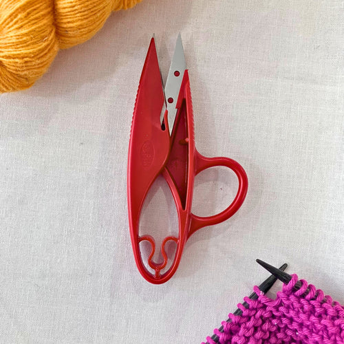 Red Milward 4.5 inch stainless steel thread snips on muslin fabric background.