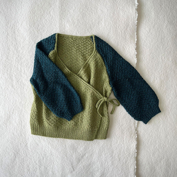 Bow Snug Baby Jacket knitting pattern by Pascuali — infant knitted jacket with bow detail. Pinta — merino, silk, ramie. Photo courtesy of Pascuali.
