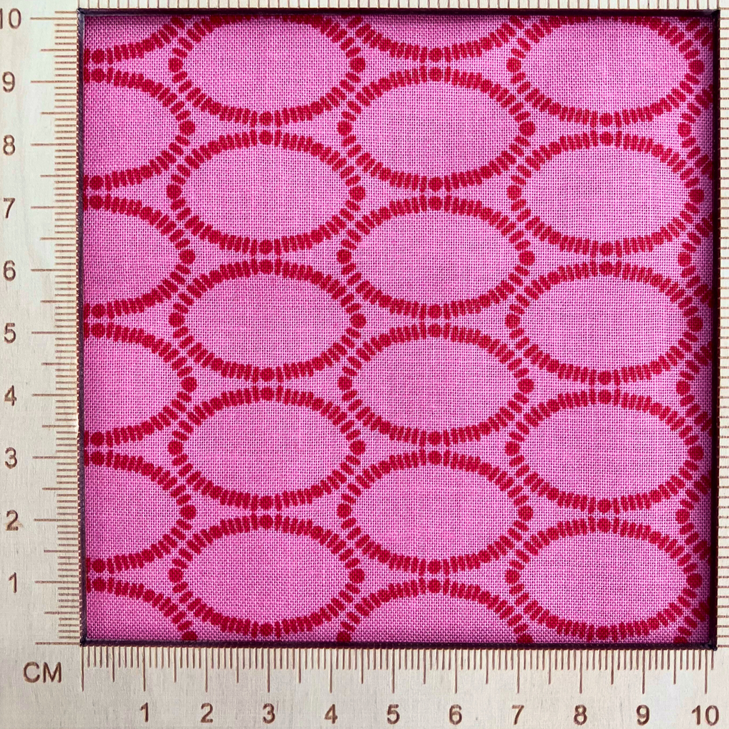 4"x4" scale — 100% cotton quilting fabric — geometric ovals in red on a rich raspberry background. 44/45in width.