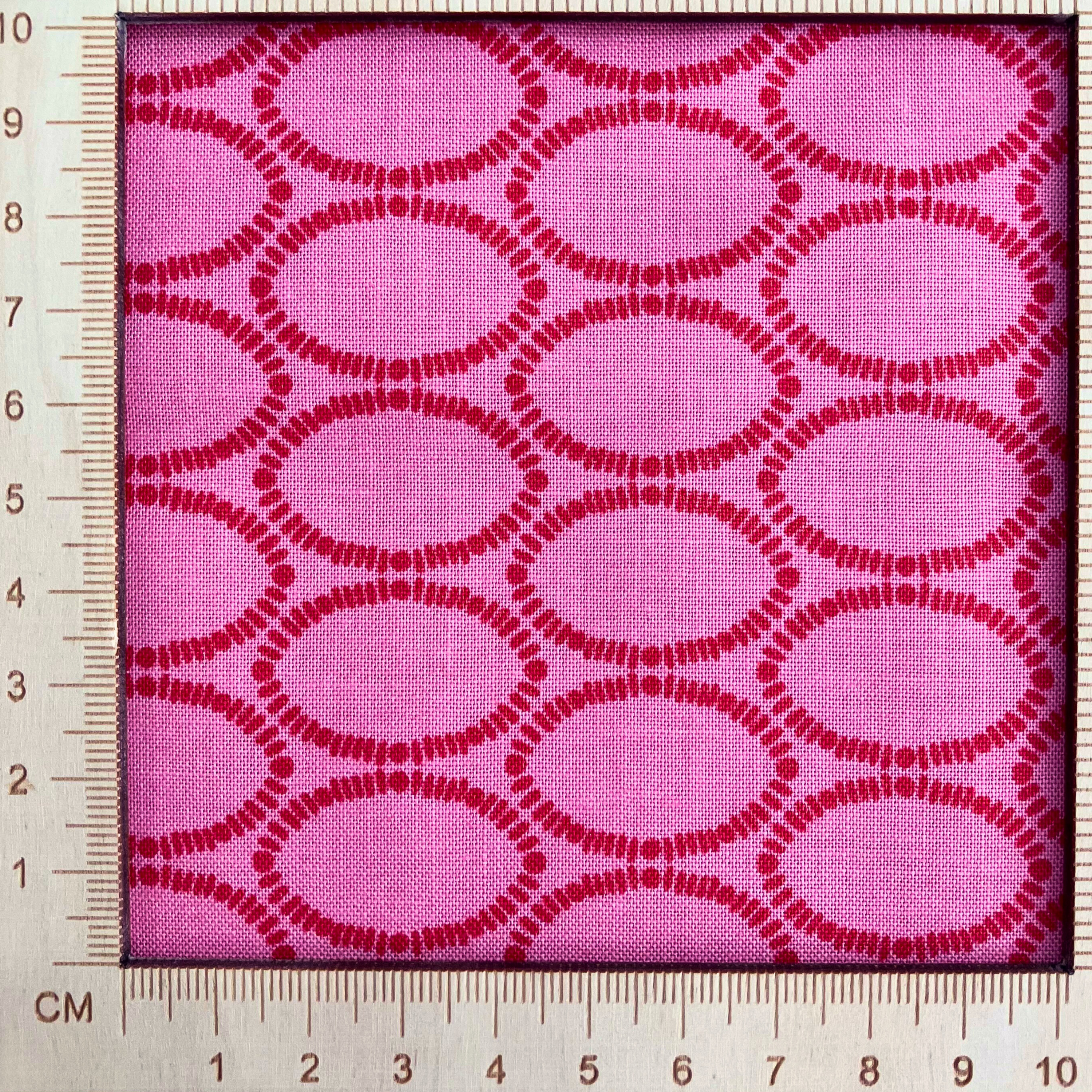 4"x4" scale — 100% cotton quilting fabric — geometric ovals in red on a rich raspberry background. 44/45in width.