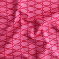 100% cotton quilting fabric — geometric ovals in red on a rich raspberry background. 44/45in width.