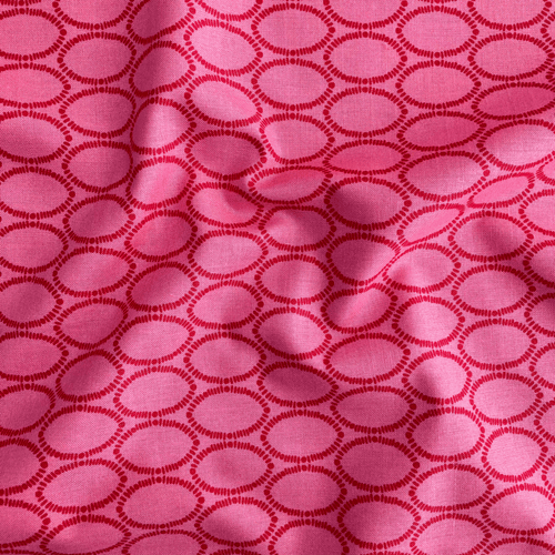 100% cotton quilting fabric — geometric ovals in red on a rich raspberry background. 44/45in width.