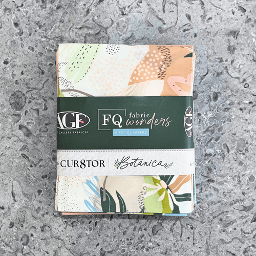 100% cotton quilting fabric — set of eight fat quarters — fabrics with florals, leaves, and organic textures patterns of soft pinks & greens. 'Art Gallery Fabrics Fat Quarters Fabric Wonders Botanica' label visible.