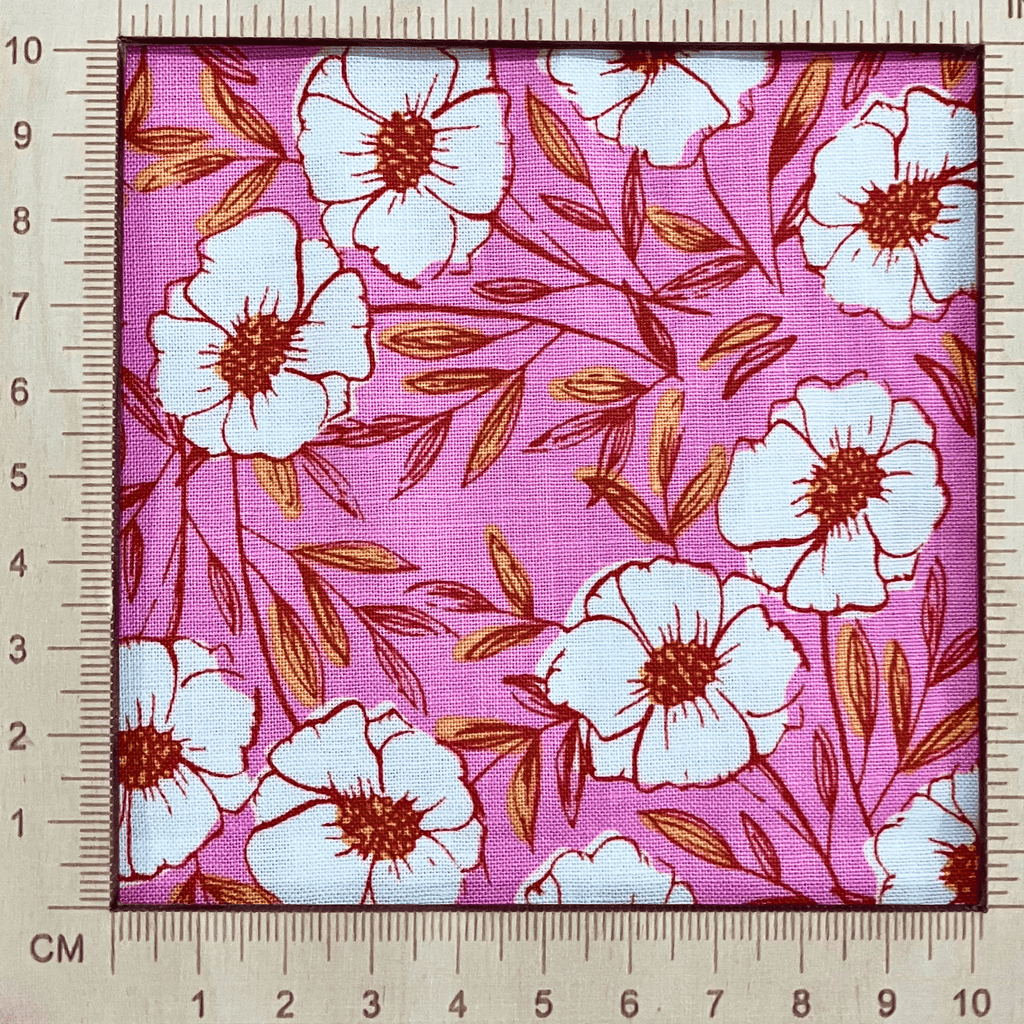 4"x4" scale —  100% cotton quilting fabric — pink fabric with white flowers with red & yellow centres. 44/45in width.