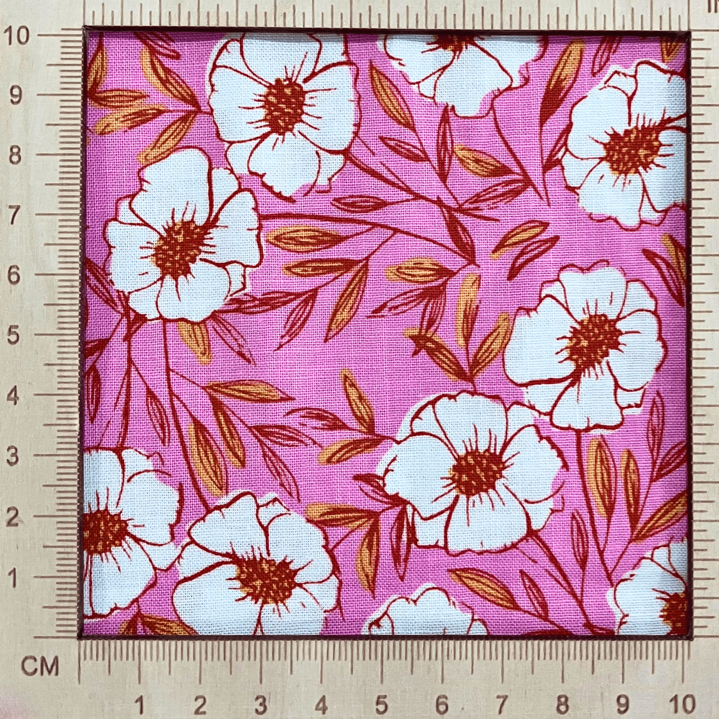 4"x4" scale —  100% cotton quilting fabric — pink fabric with white flowers with red & yellow centres. 44/45in width.
