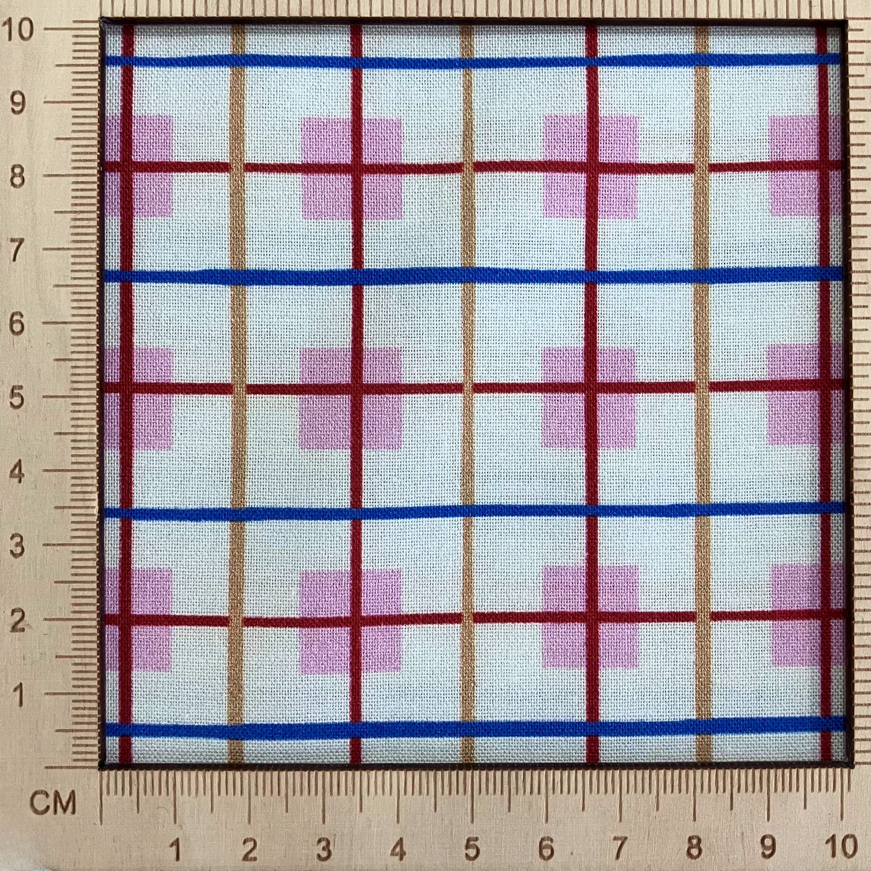 4"x4" scale — 100% cotton quilting fabric — Cream fabric with orange, blue, and red stripes intersect on pink squares. 44/45in width.