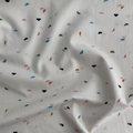 100% cotton quilting fabric — light cream fabric with green, blue, pink, orange, and black crescent shapes. 44/45in width.