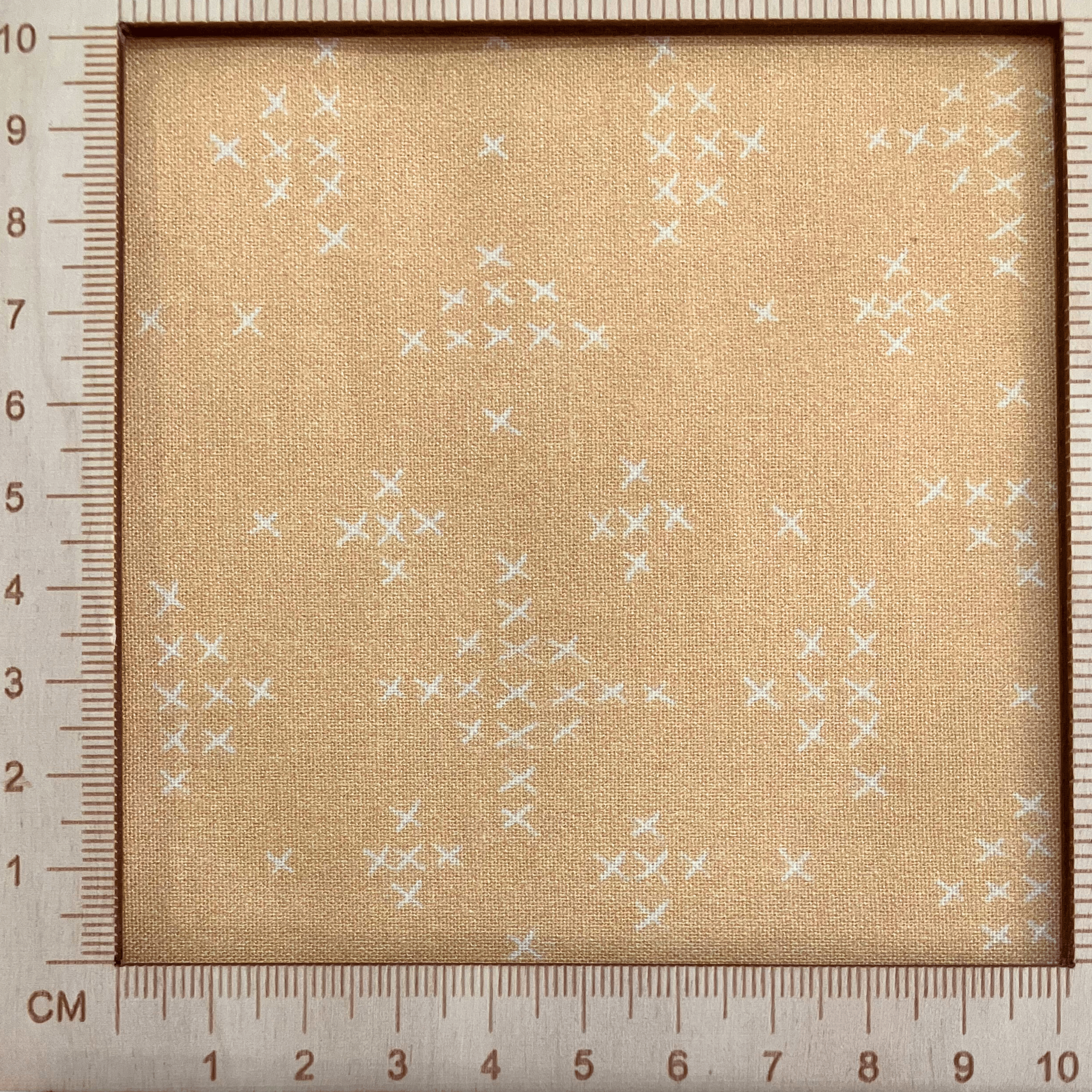 4"x4" scale — 100% cotton quilting fabric — warm yellow-orange fabric with tiny white x’s. 44/45in width.