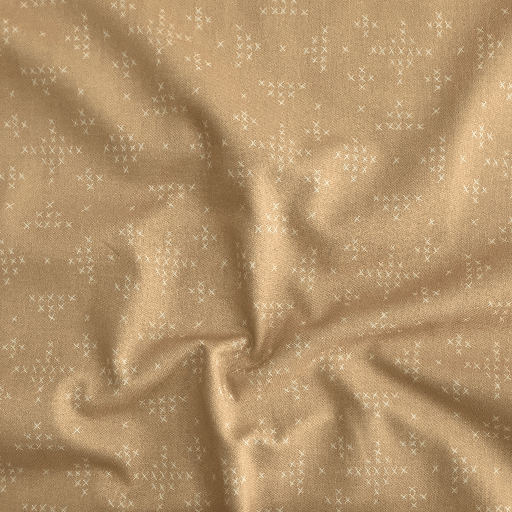 100% cotton quilting fabric — warm yellow-orange fabric with tiny white x’s. 44/45in width.