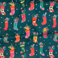 Christmas Stockings quilting cotton — illustrated Christmas stockings stuffed with candy canes and gingerbread on a deep teal background with white stars. Dashwood Studio, 44/45″ wide.