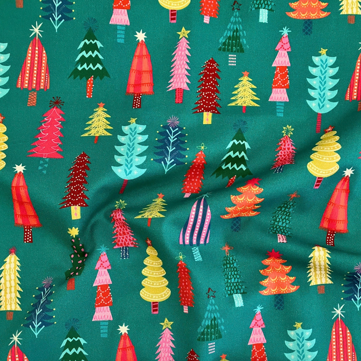 Christmas Trees quilting cotton — illustrated Christmas trees in red, pink, teal, yellow and orange on a bold teal background. Dashwood Studio Candy Cane Christmas collection, 44/45″ wide.