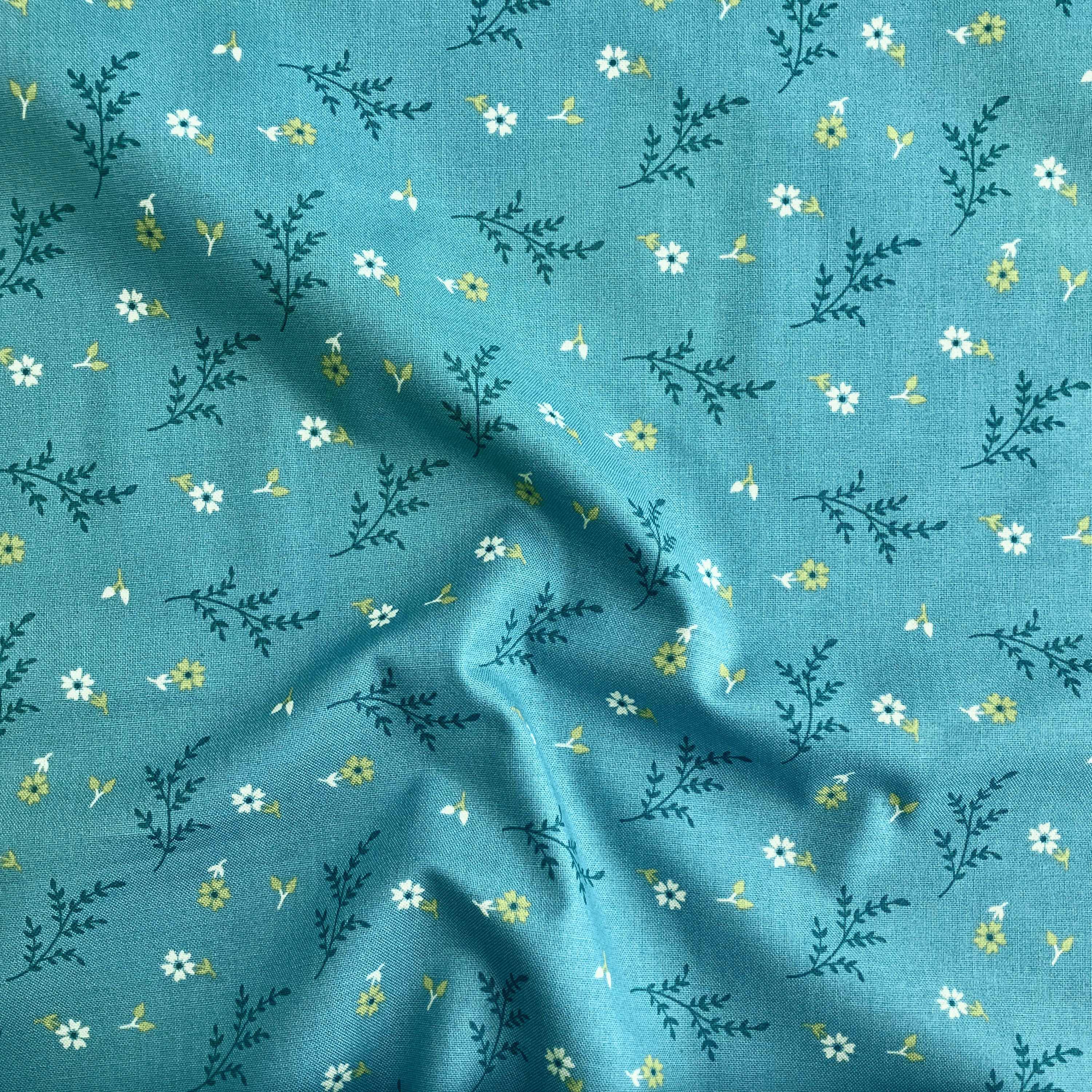 100% cotton quilting fabric — white flowers & green leaves on teal. 43/44in width.