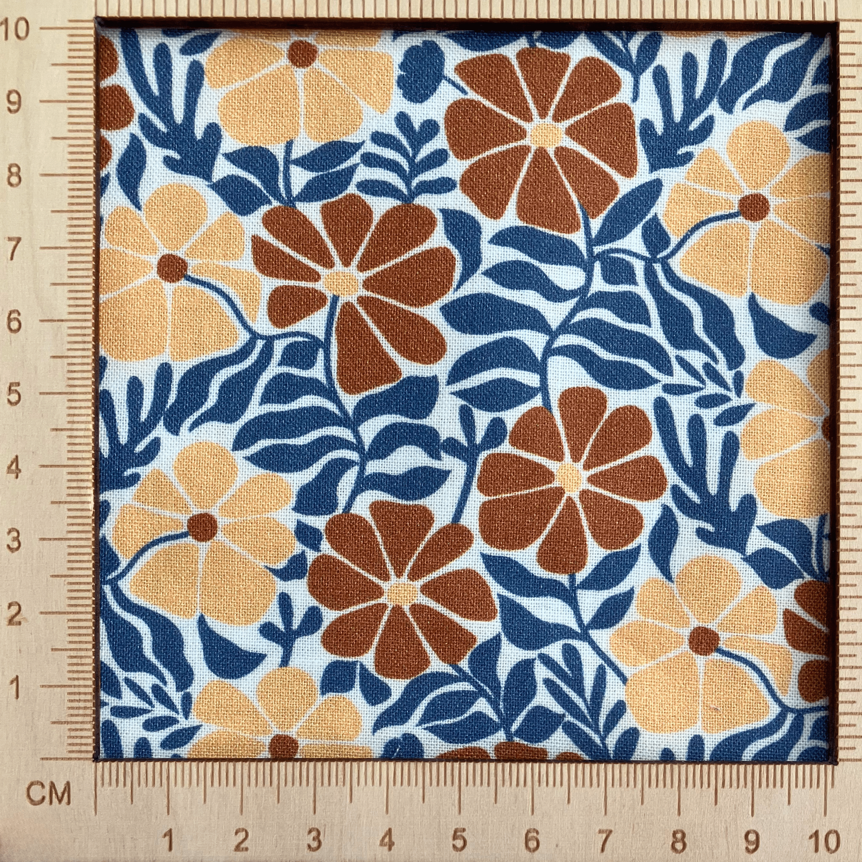 4"x4" scale — 100% cotton quilting fabric — burnt orange & tan flowers with blue-grey leaves on white. 43/44in width.