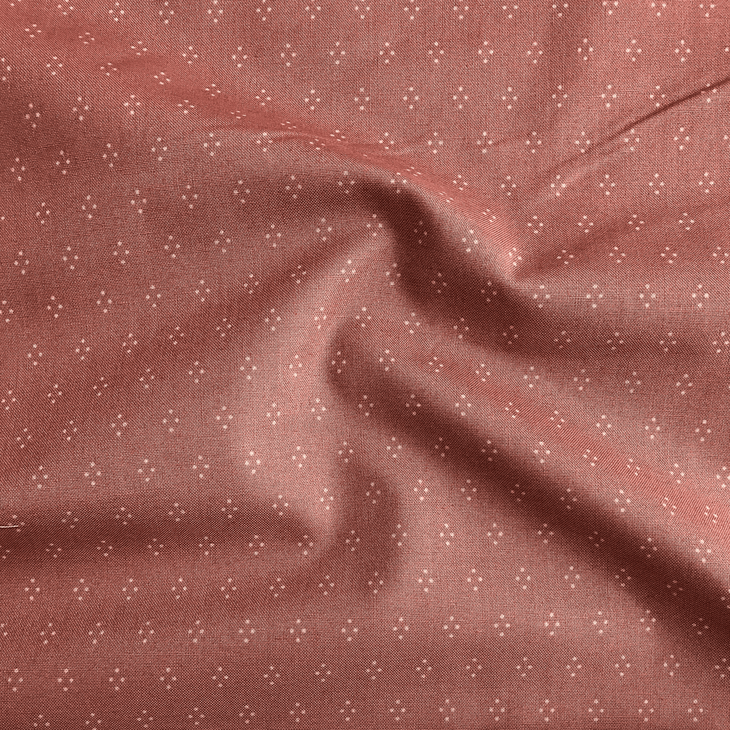 100% cotton quilting fabric — white dot diamonds on muted rose. 43/44in width.