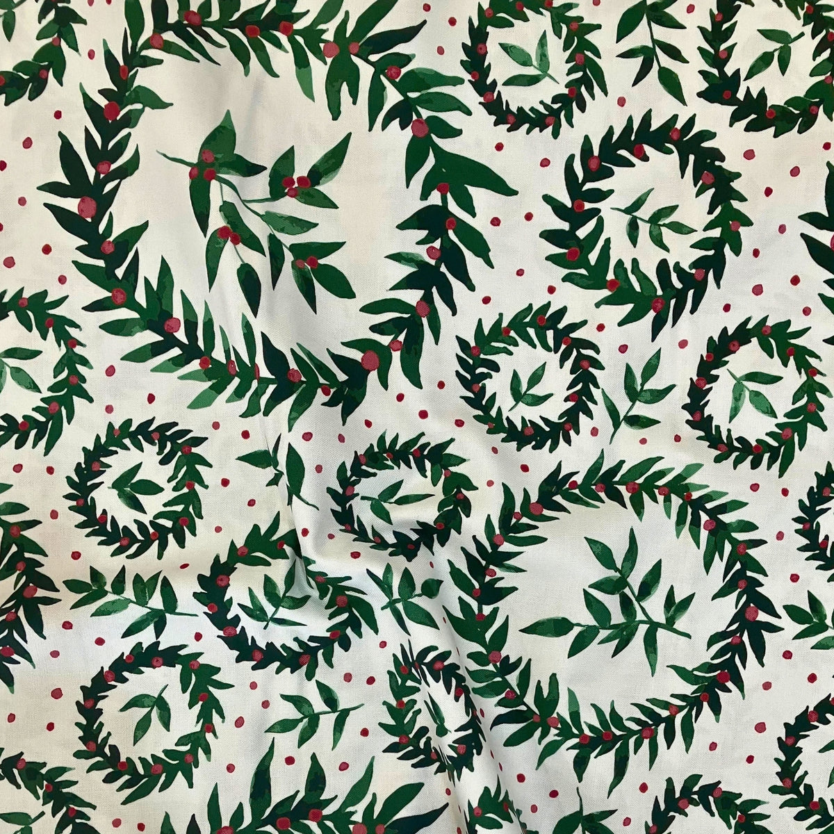 Encircled quilting cotton — painterly holly wreaths and leafy sprigs with red berries on a cream background. Phoebe Fabrics Wintry collection, 43/44″ wide. Canadian.
