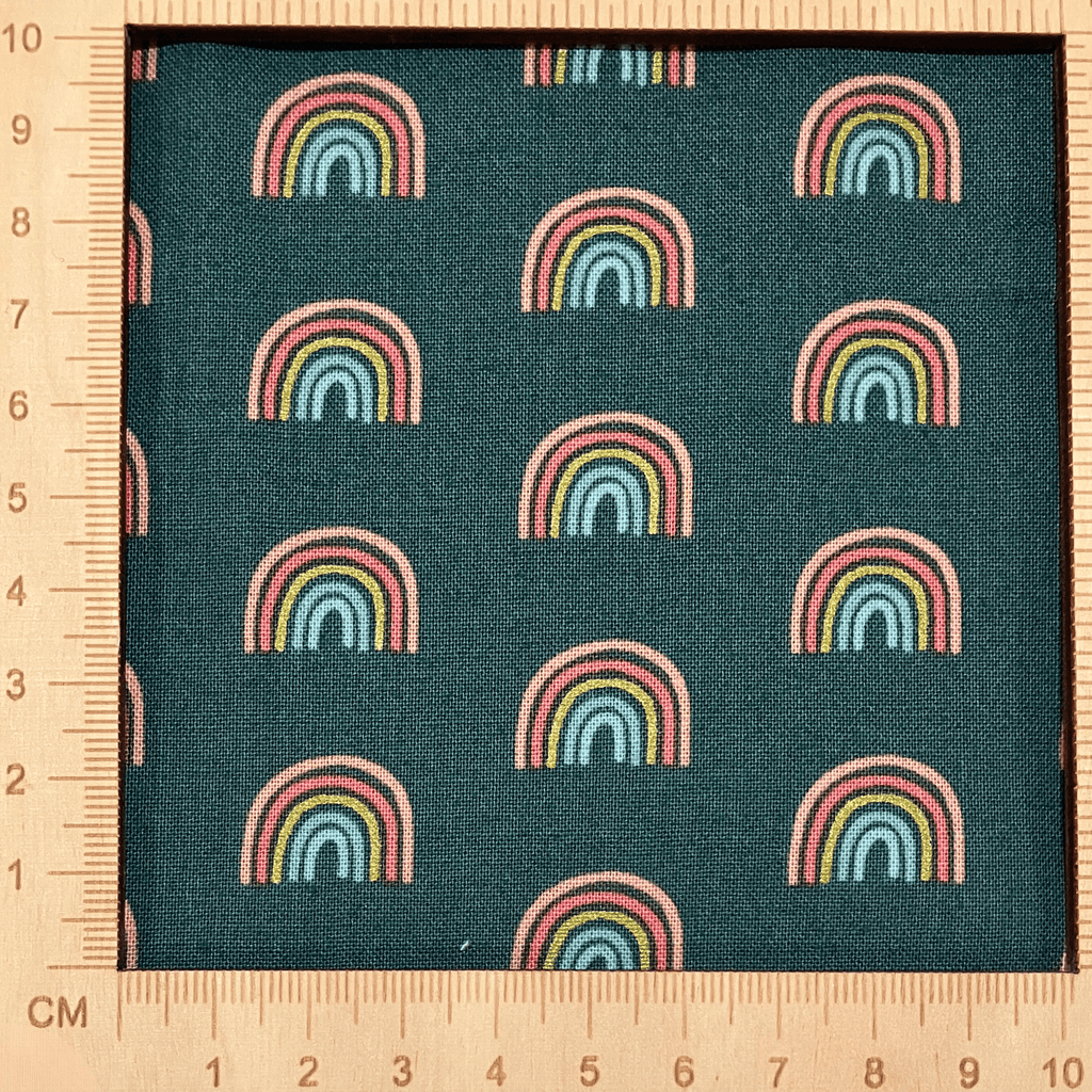 4"x4" scale — 100% cotton quilting fabric — small rainbows on dark green. 43/44in width.
