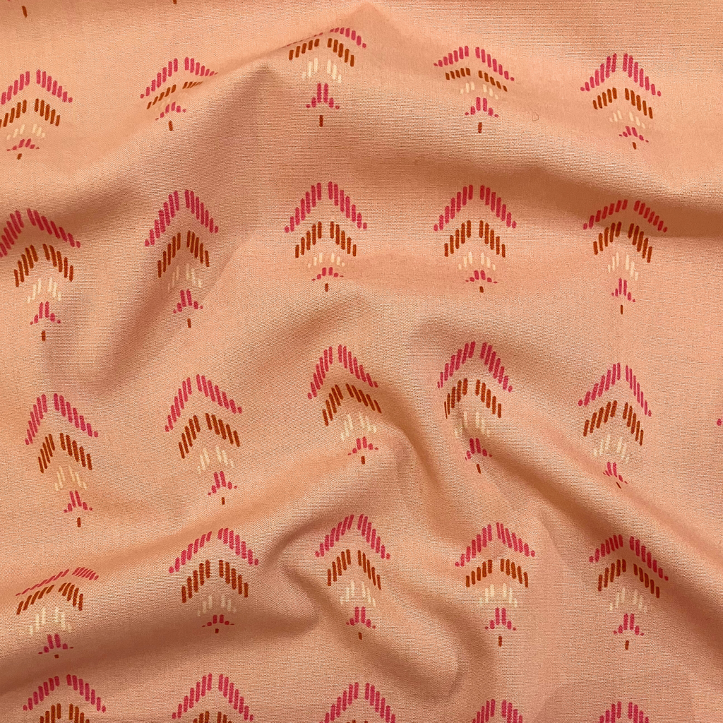 100% cotton quilting fabric — pink & orange feather-like shapes on light coral. 44/45in width.