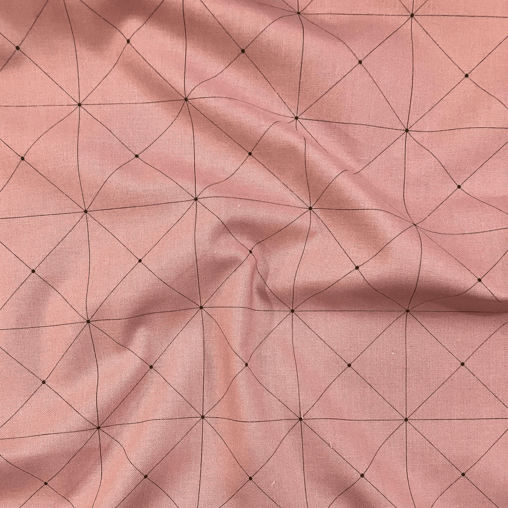 100% cotton quilting fabric — thin green grid lines on dusty pink. 44in width.