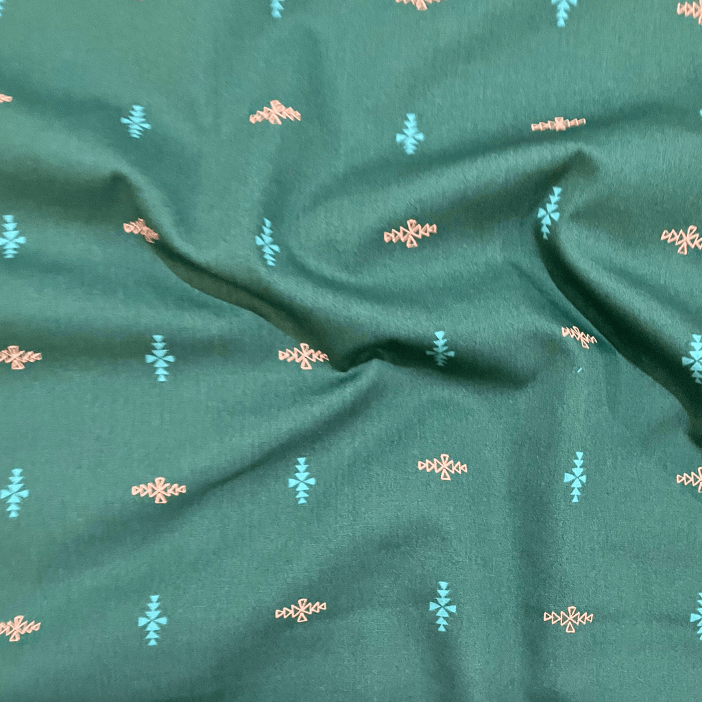 100% cotton quilting fabric — blue & orange triangles in diamond formations on dark blue-green. 44in width.