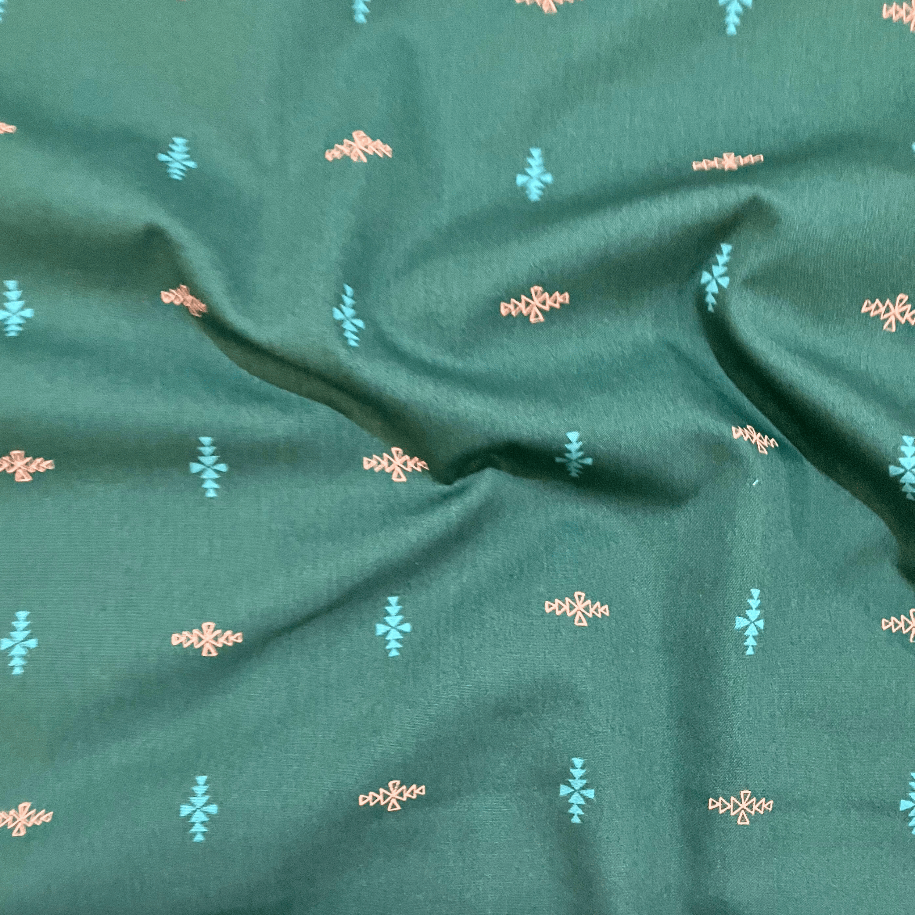 100% cotton quilting fabric — blue & orange triangles in diamond formations on dark blue-green. 44in width.