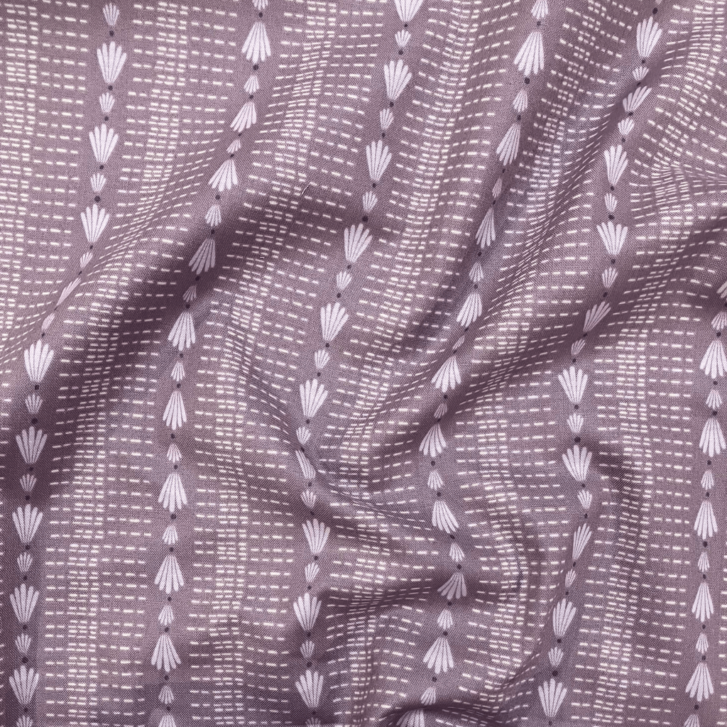 100% cotton quilting fabric — repeated shell & dash lines on grey-purple. 44/45in width.