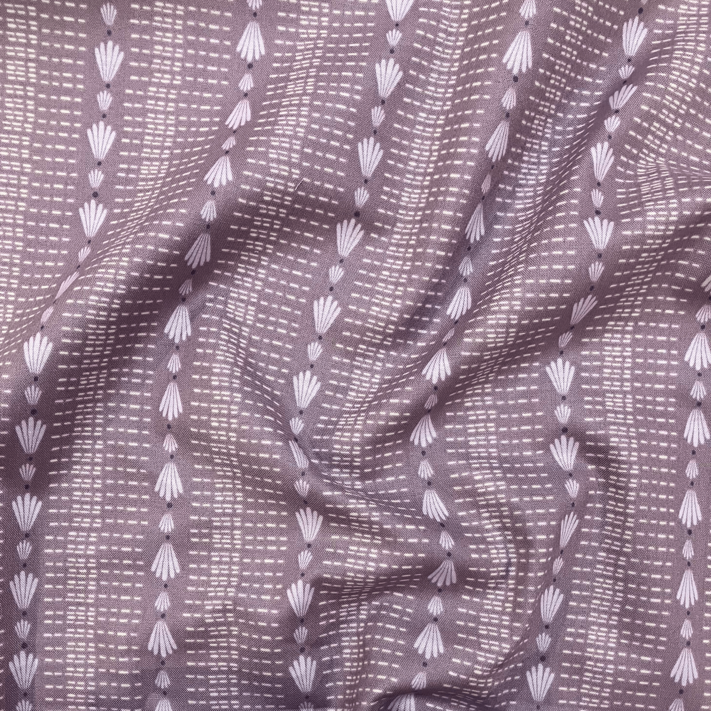 100% cotton quilting fabric — repeated shell & dash lines on grey-purple. 44/45in width.