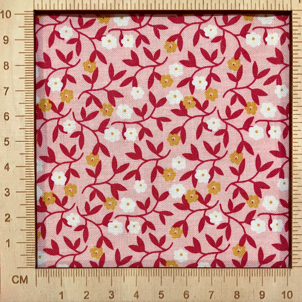 4"x4" scale — 100% cotton quilting fabric — small white & orange flowers on light coral. 43/44in width.