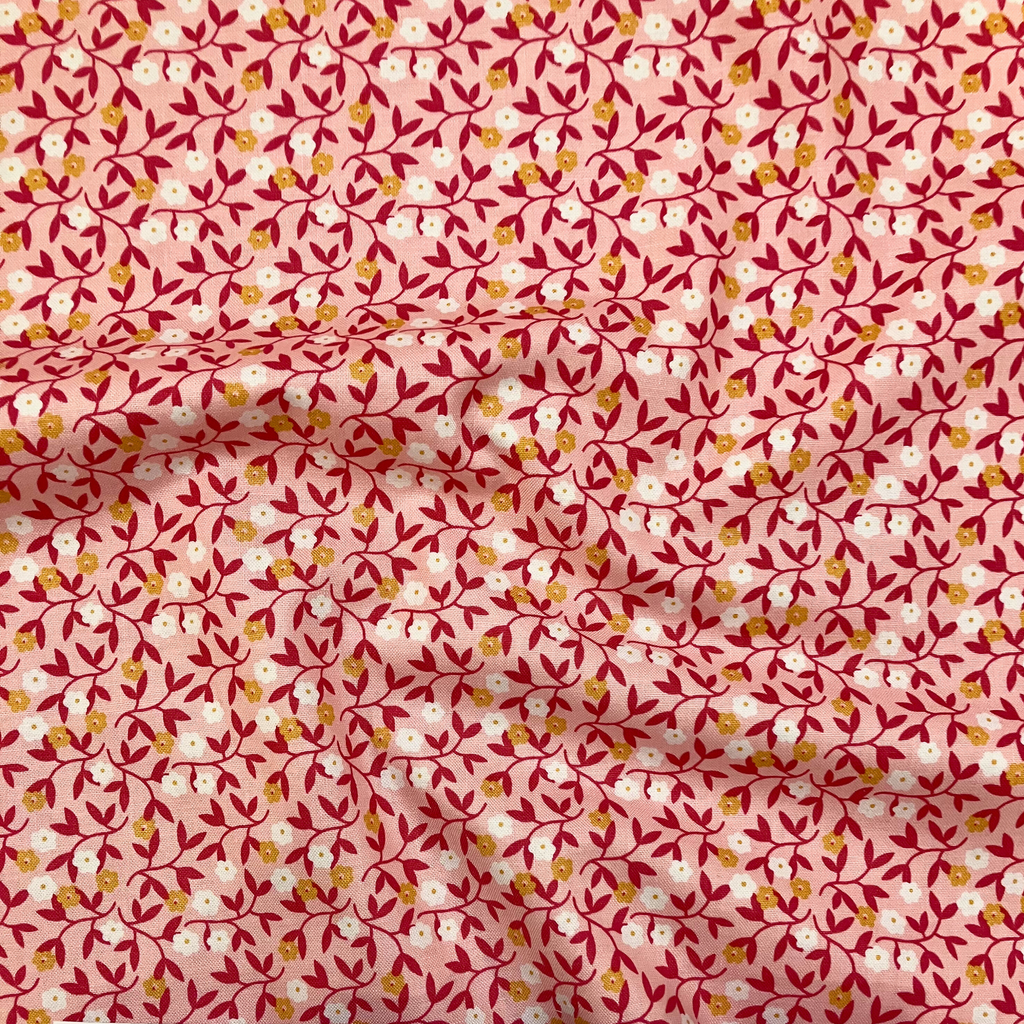 100% cotton quilting fabric — small white & orange flowers on light coral. 43/44in width.