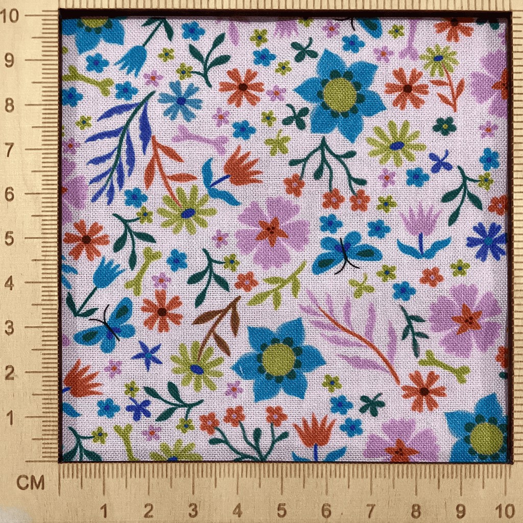4"x4" scale — 100% cotton quilting fabric — colourful floral pattern on a pale pink. 43/44in width.