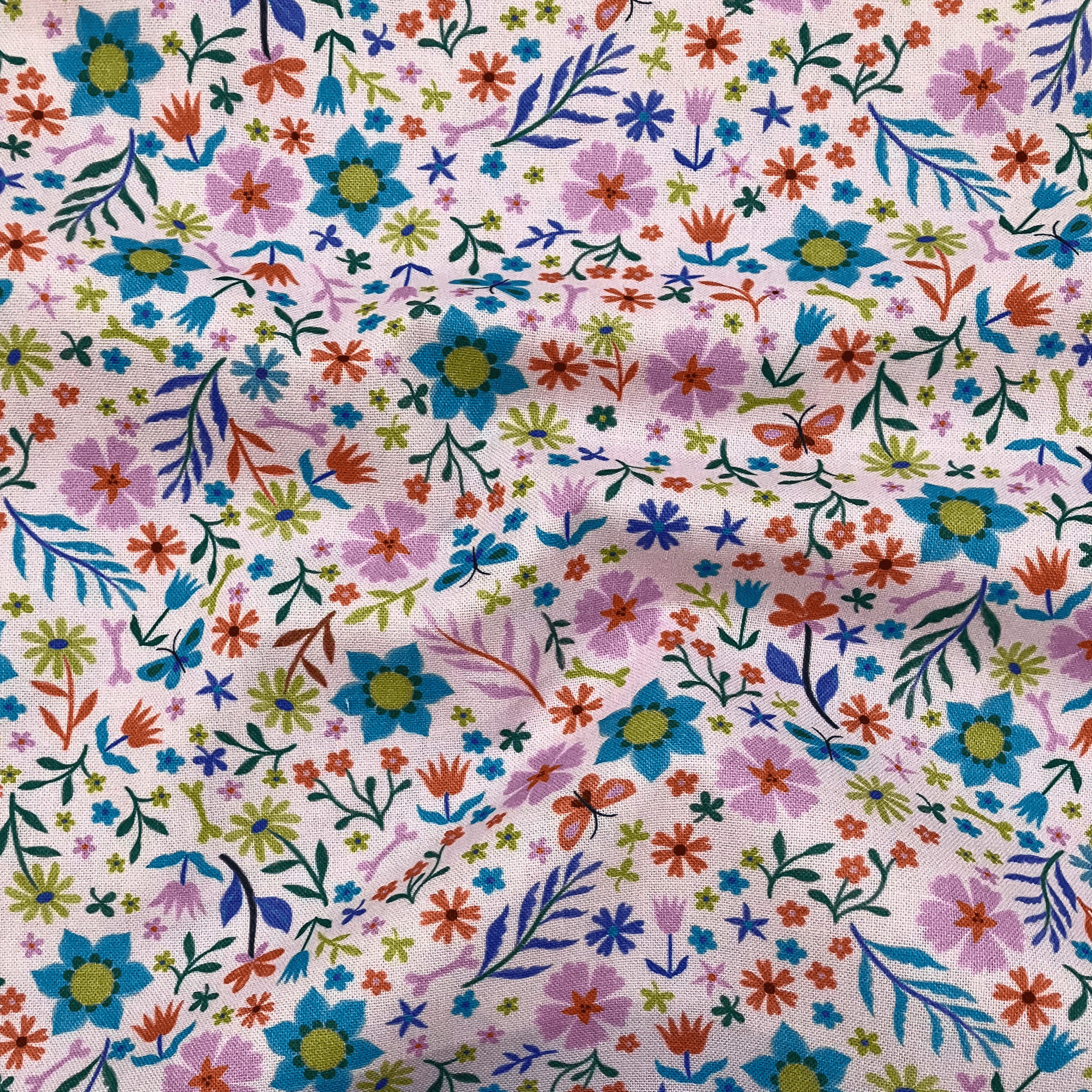 100% cotton quilting fabric — colourful floral pattern on a pale pink. 43/44in width.