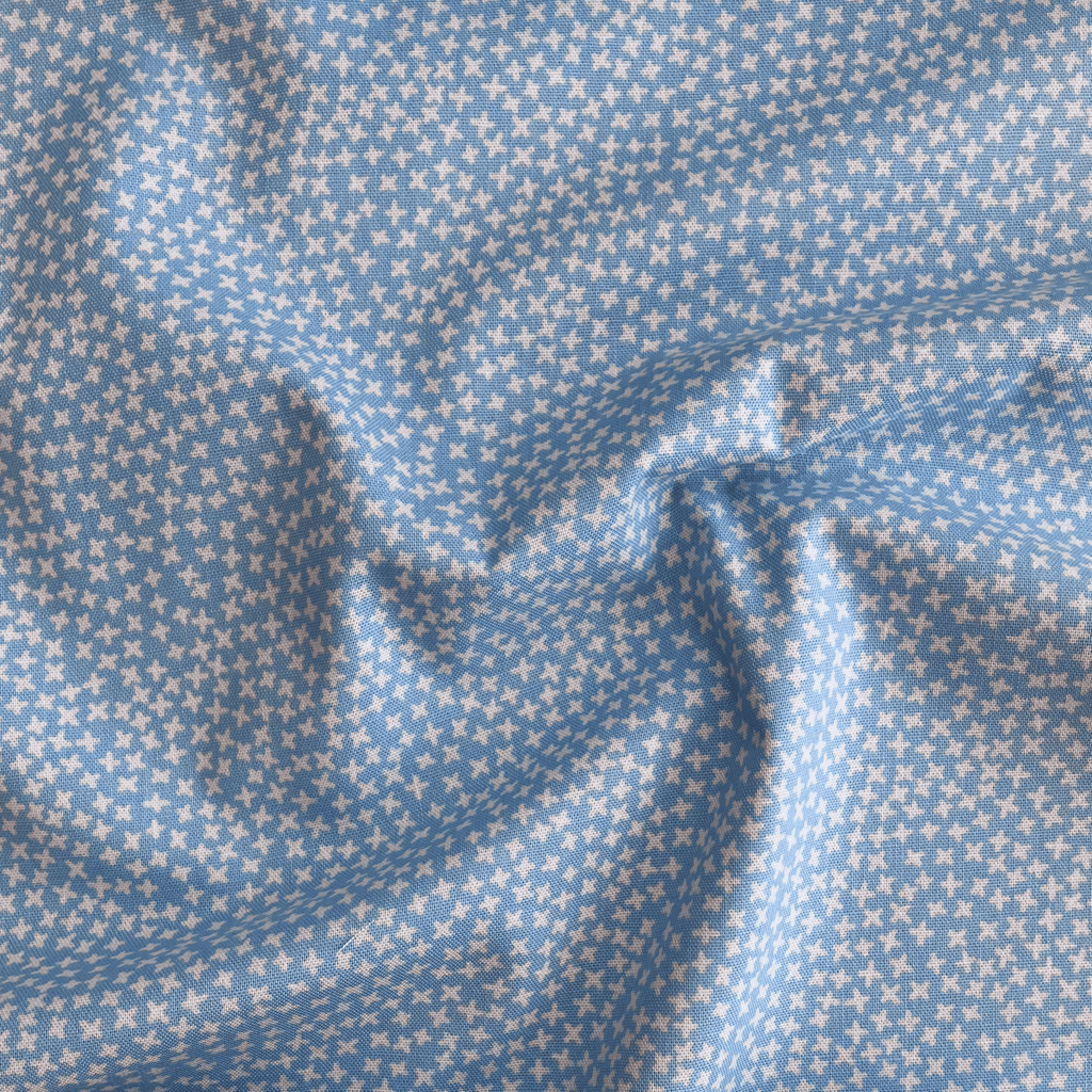 100% cotton quilting fabric — small white cross pattern on light blue. 43/44in width.