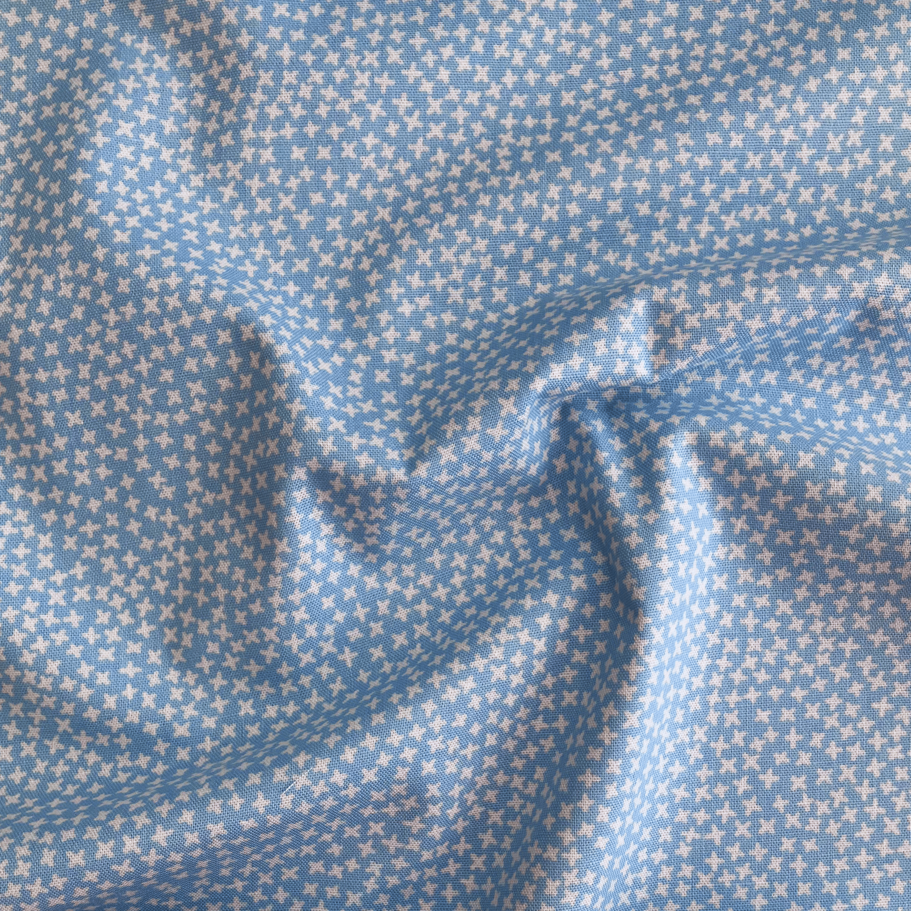 100% cotton quilting fabric — small white cross pattern on light blue. 43/44in width.