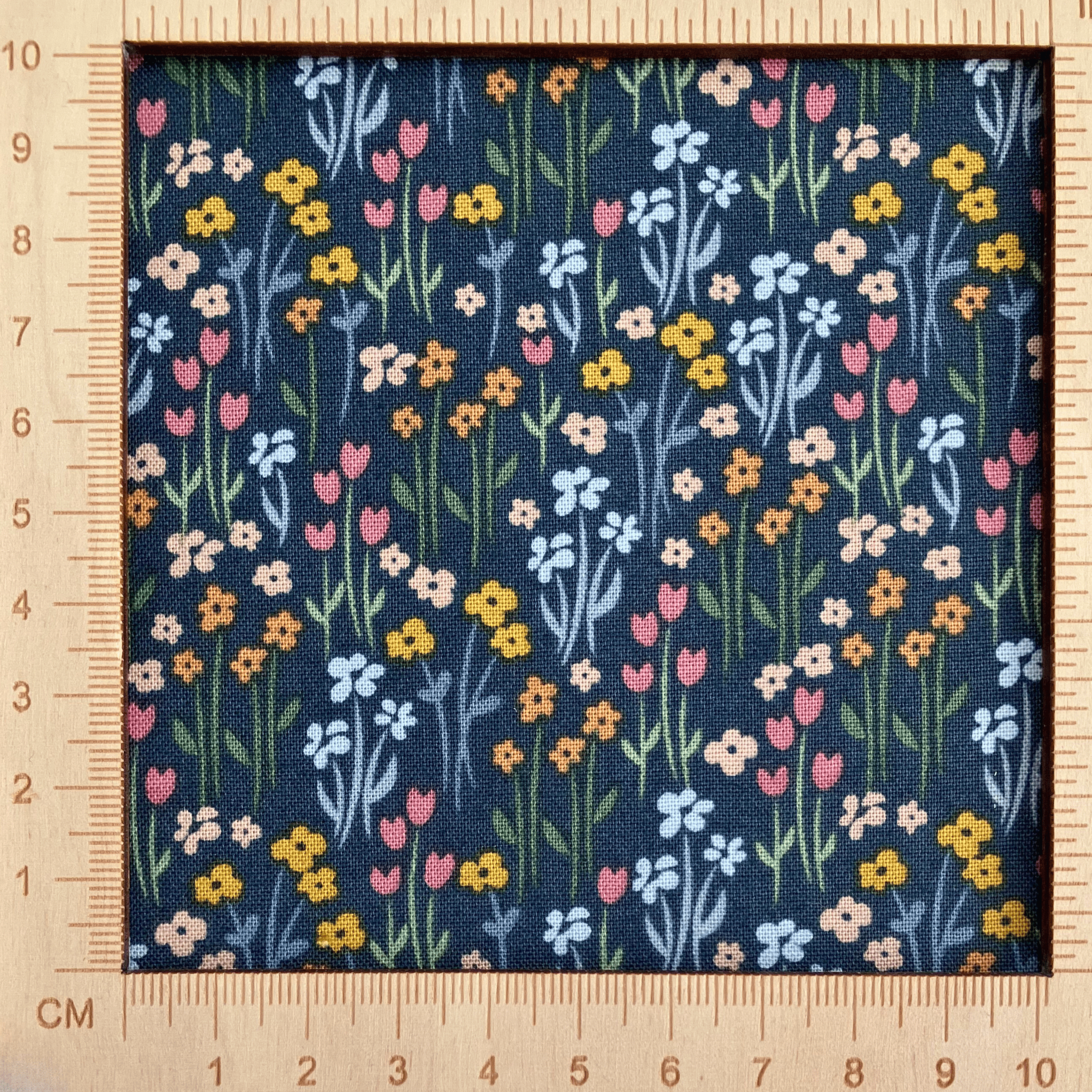 4"x4" scale — 100% cotton quilting fabric — multicoloured flowers with stems on dark green-grey. 43/44in width.