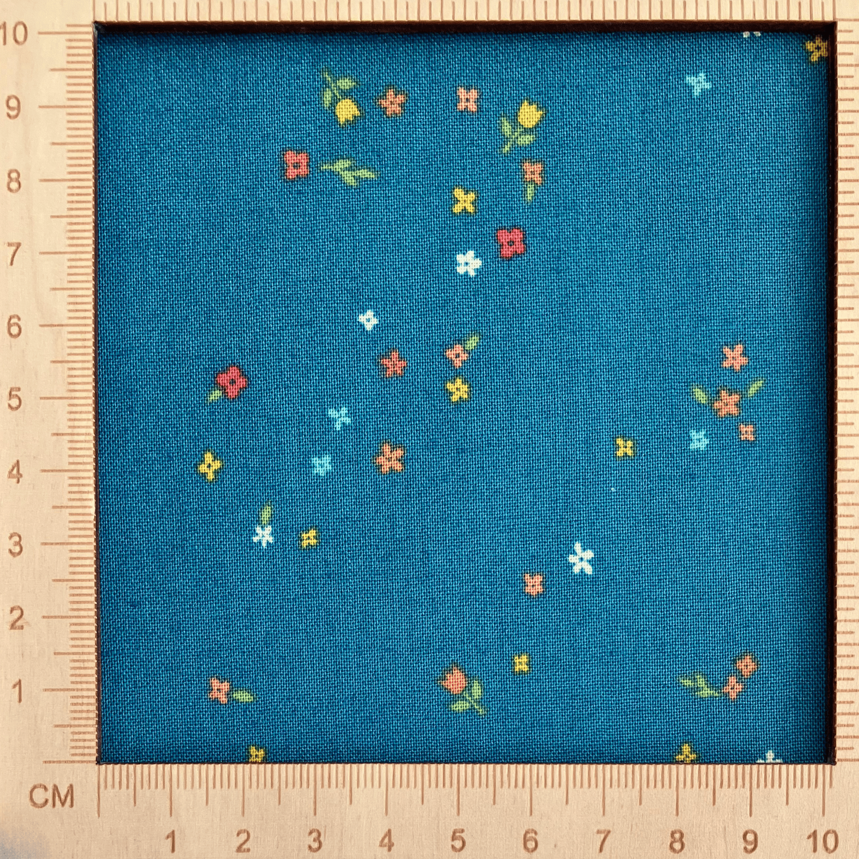 4"x4" scale — 100% cotton quilting fabric — colourful tiny blooms on deep teal. 43/44in width.