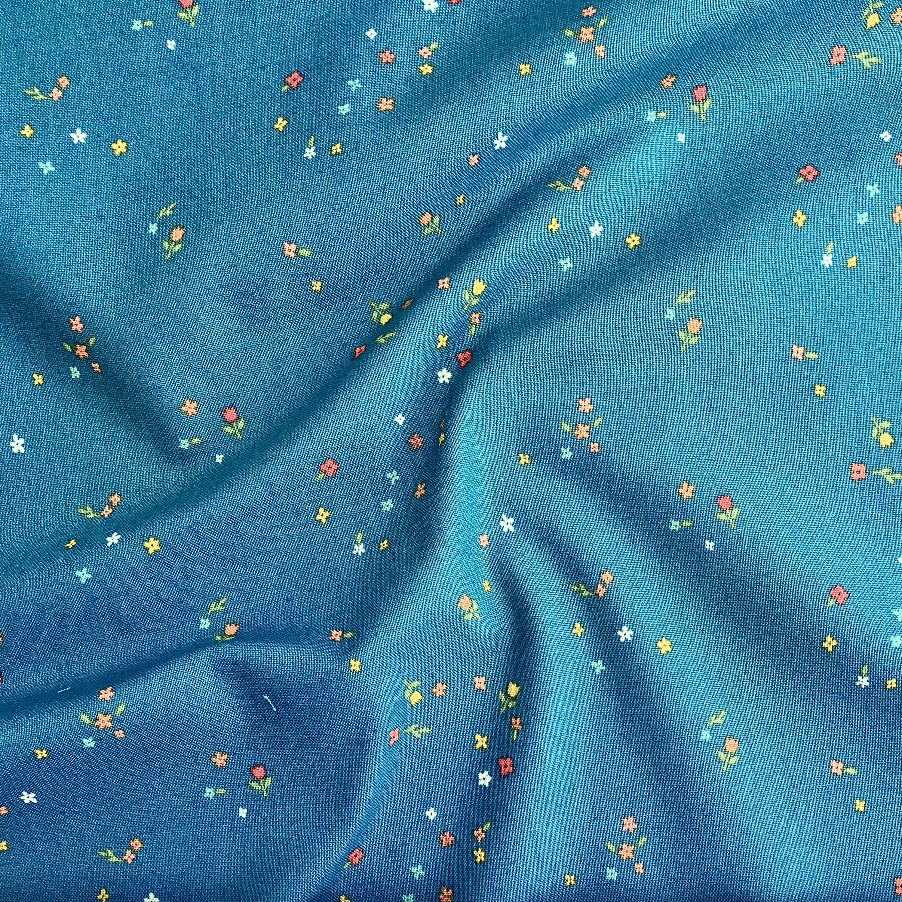 100% cotton quilting fabric — colourful tiny blooms on deep teal. 43/44in width.